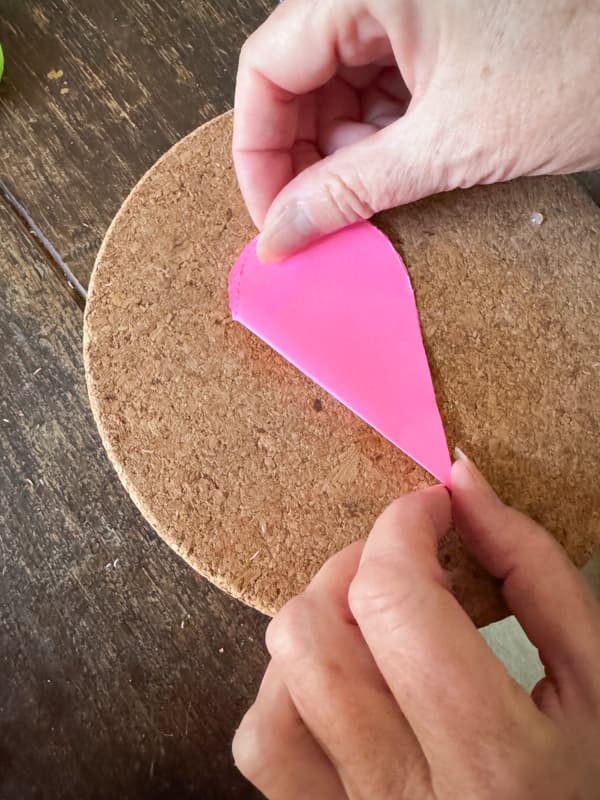 Stack folded paper hearts evenly 