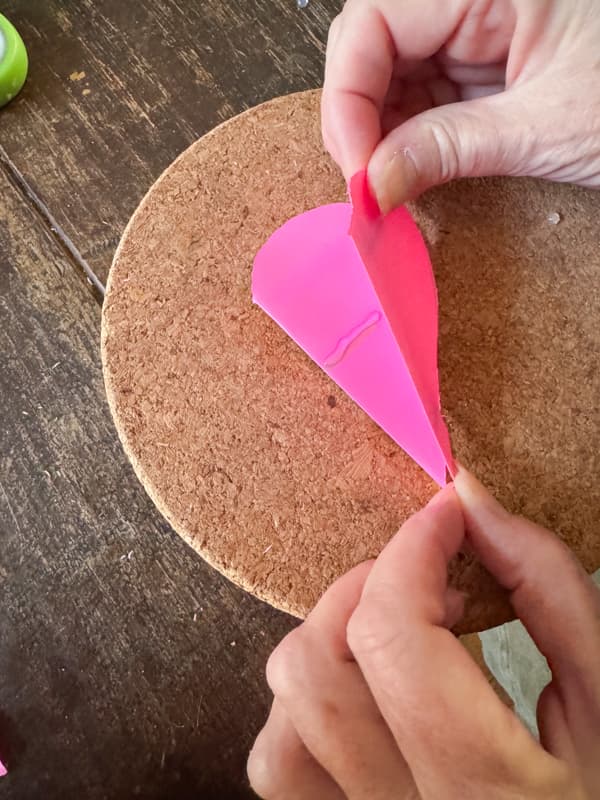 add hot glue to hold folder paper hearts together for Valentine's Day Decoration