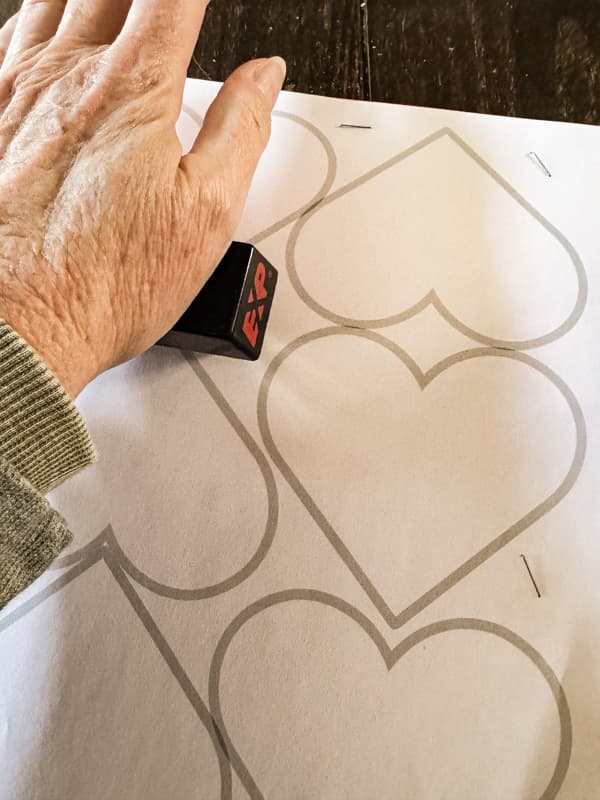 Staple paper together with heart template.