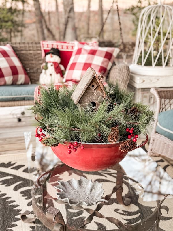 Coffee Table centerpiece is a vintage red and blue enamelware bowl filled with evergreens and a birdhouse.