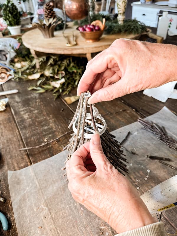 Add hot glue to twigs to attach to Dollar tree Christmas Tree Frame