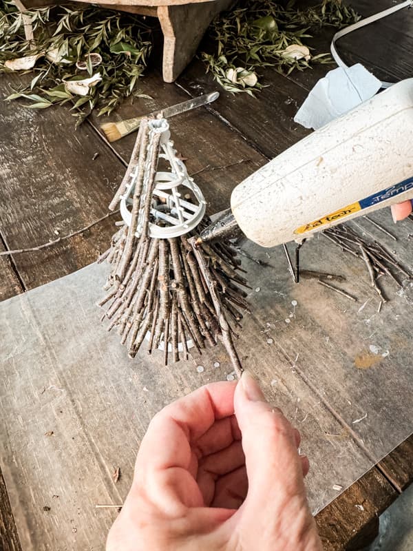 Add hot glue to twigs to attach to Dollar tree Christmas Tree Frame