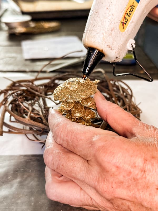 Add hot glue to bottom of pinecones