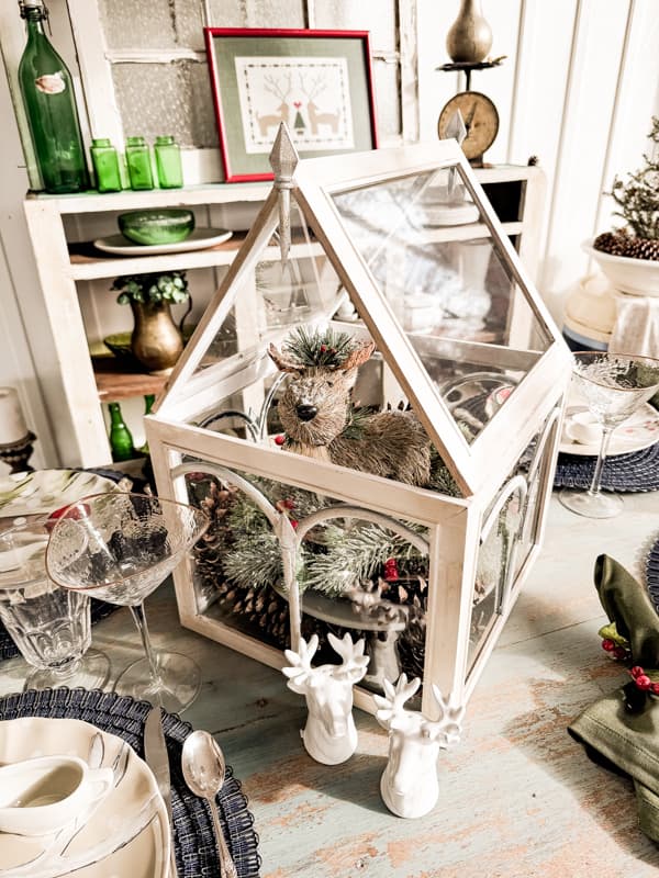 DIY Glass Terraium as centerpiece with rustic reindeer for outdoor Christmas Tablescape ideas. 