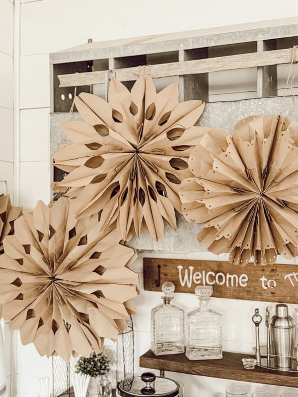 3-D Snowflakes are hanging from the vintage nesting box over the farmhouse loft bar.  