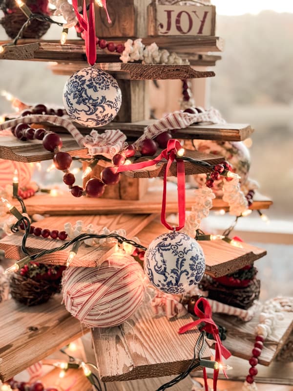 Shiplap Christmas Tree for outdoor Christmas Decorating ideas on Screen Porch with red and blue ornaments. 