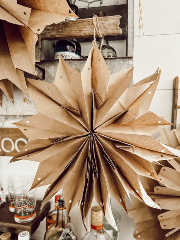 Small Paper Bag Snowflake made with brown lunch bags on loft bar.