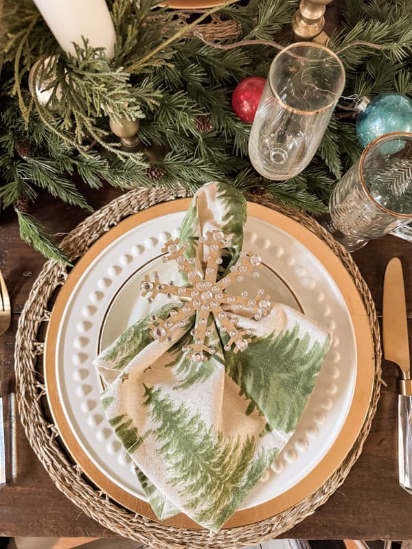 DIY Christmas Napkin Rings made with Christmas tree napkins on white plate with gold charger for Holiday Tablescape.