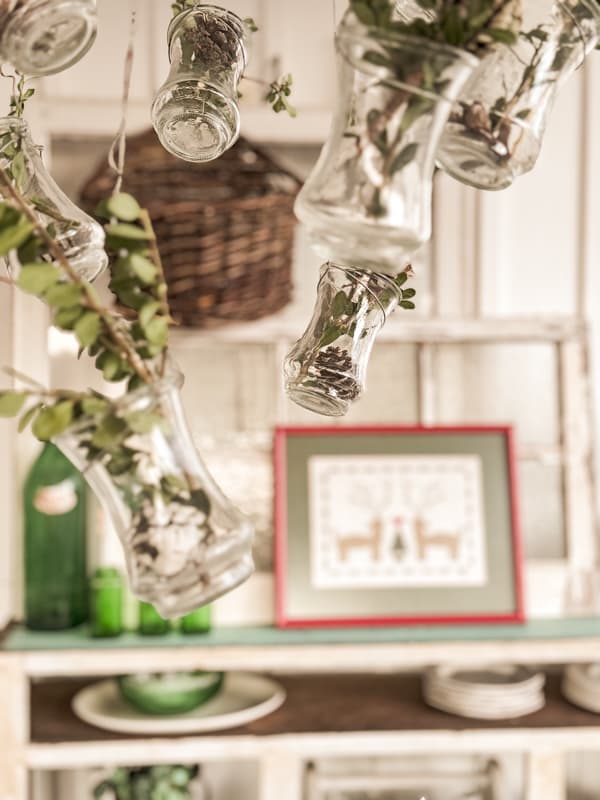 add boxwood clippings to hanging glass vases on porch light fixture.