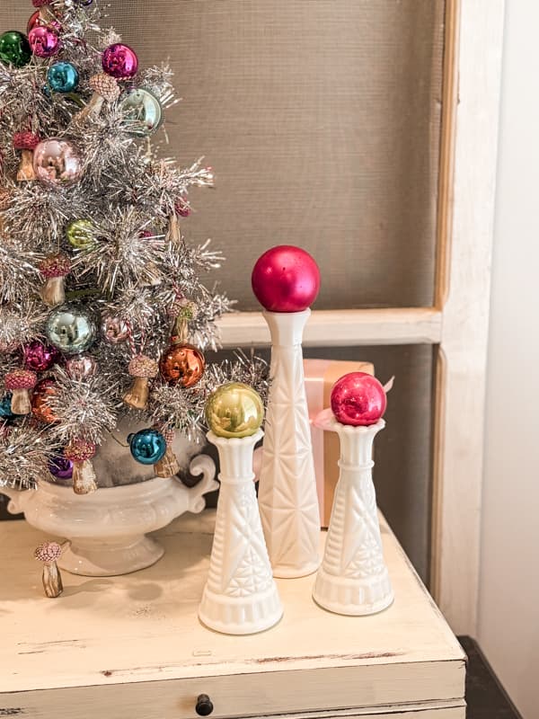 Add ornaments to milk glass bud vases.  