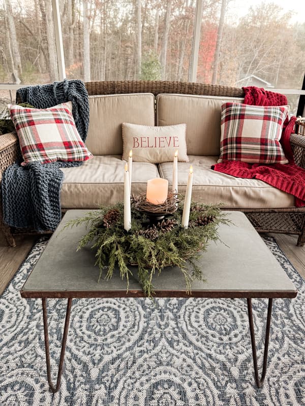 Screen Porch with blue and white rug, DIY advent wreath and red and blue sofa blankets and pillows