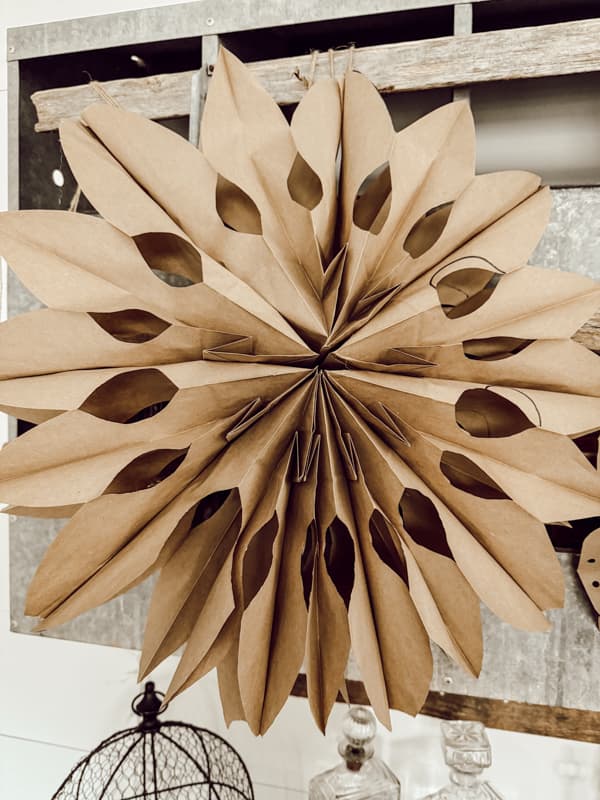 Brown kraft paper bag 3-D snowflake on vintage nesting box.