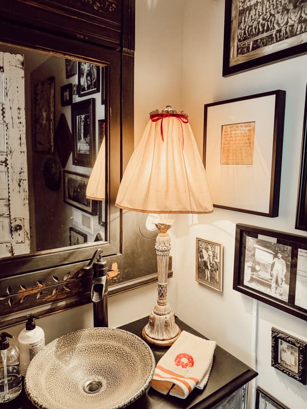 Red bow tiled onto a lampshade in powder room