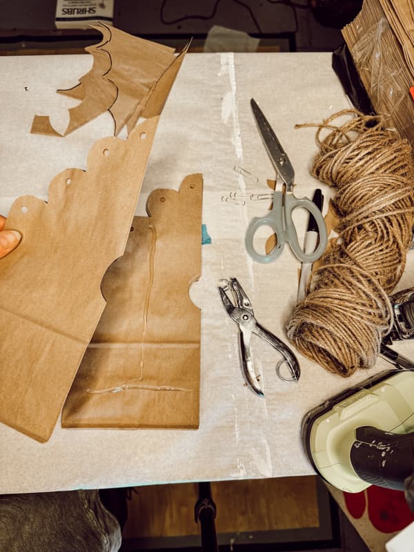 Add hot glue to paper bag to create DIY 3 -D Snowflakes with jute twine scissors and hole punch