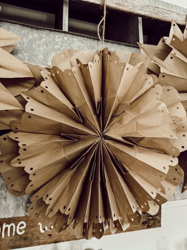 Small Paper Bag Snowflake made with brown lunch bags on loft bar. 