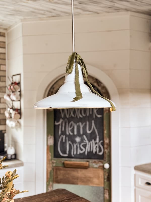 Green velvet ribbon tied in a bow on kitchen light fixture.  