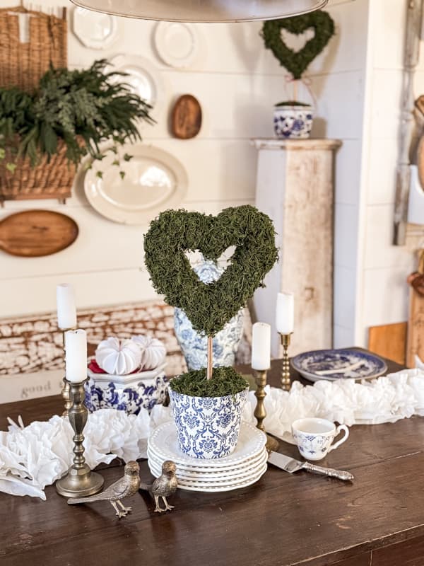 Dollar Tree Valentine's decor - DIY Moss Heart Topiary on dining table with blues and whites